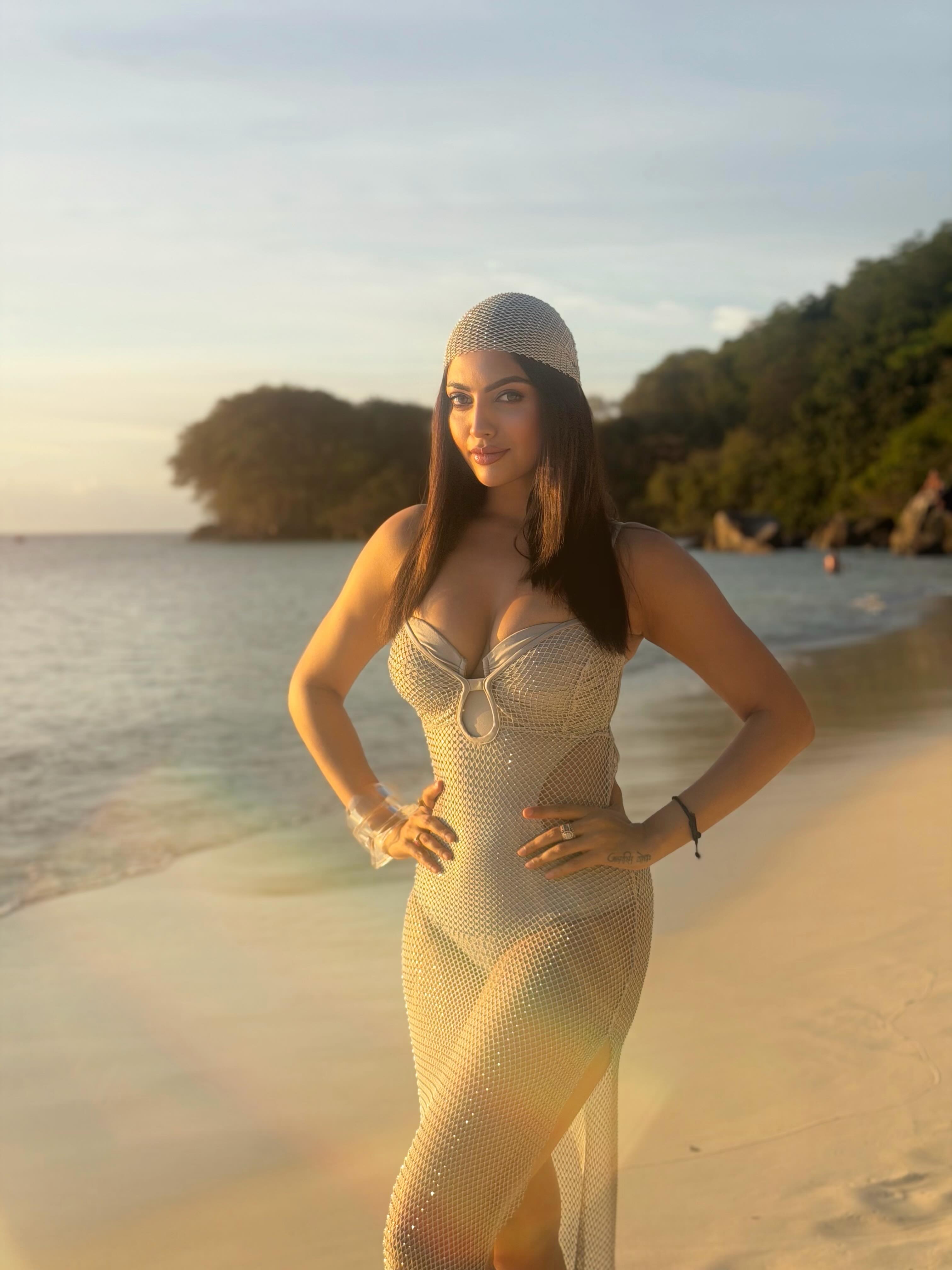 Akanksha Puri makes a striking statement in a figure-skimming embellished mesh dress featuring a structured neckline and eye-catching cut-out detail.