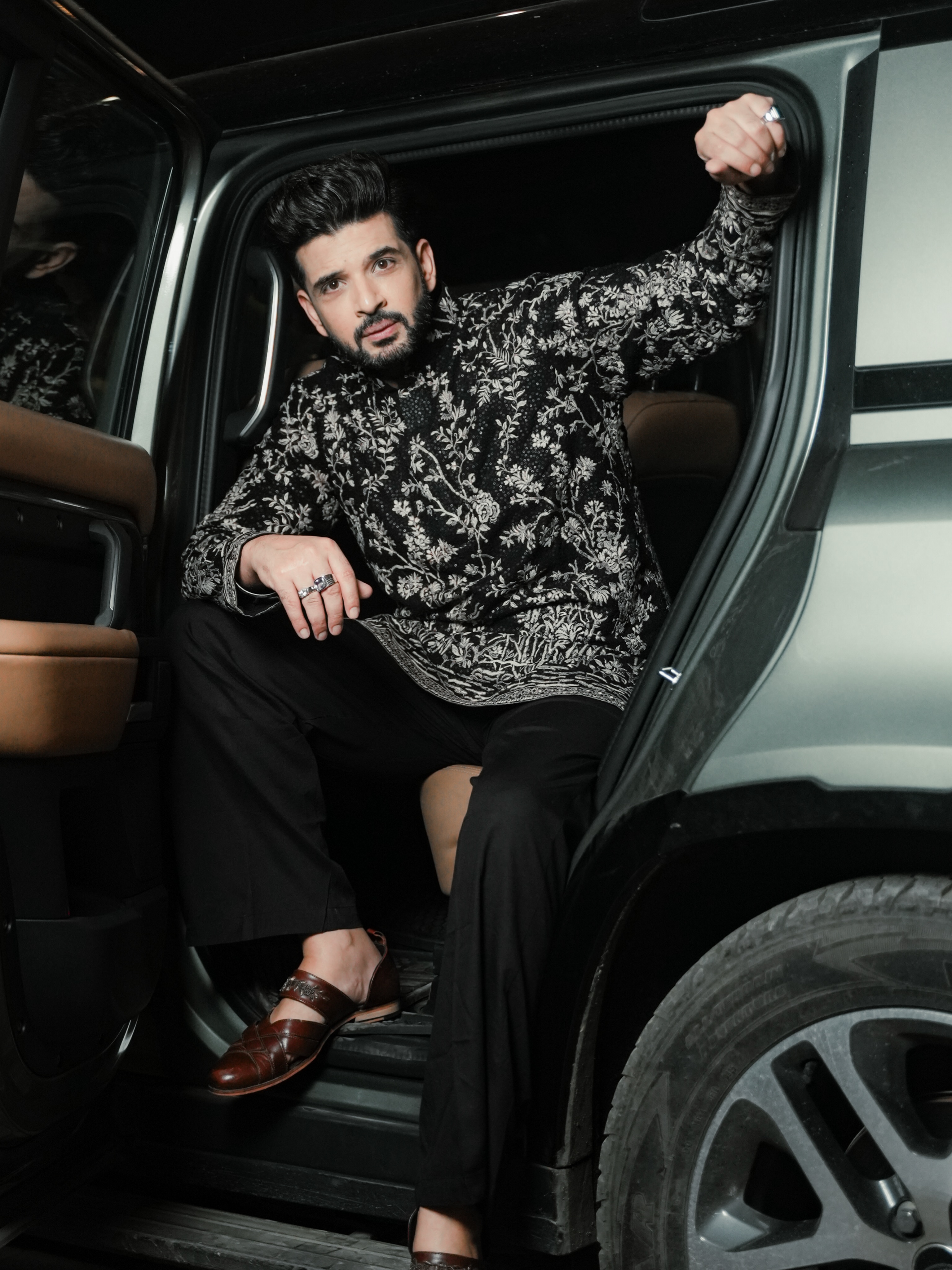 Karan Kundrra completes the look with a neatly groomed beard, voluminous hairstyle, and polished footwear that enhance the outfit's sophisticated appeal.