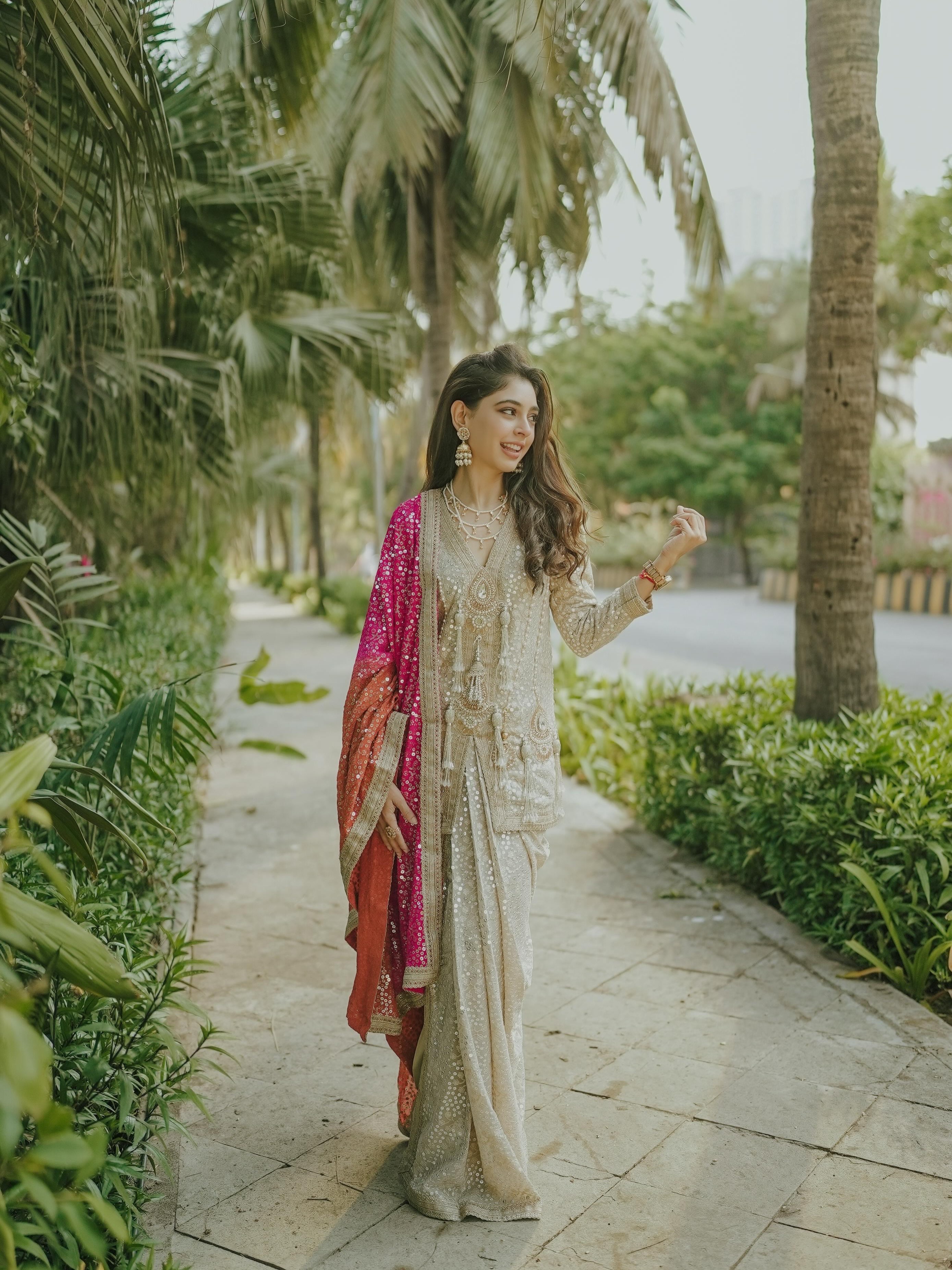 Niti Taylor adds a lively touch to the look with a striking pink dupatta that instantly elevates the monochrome palette.