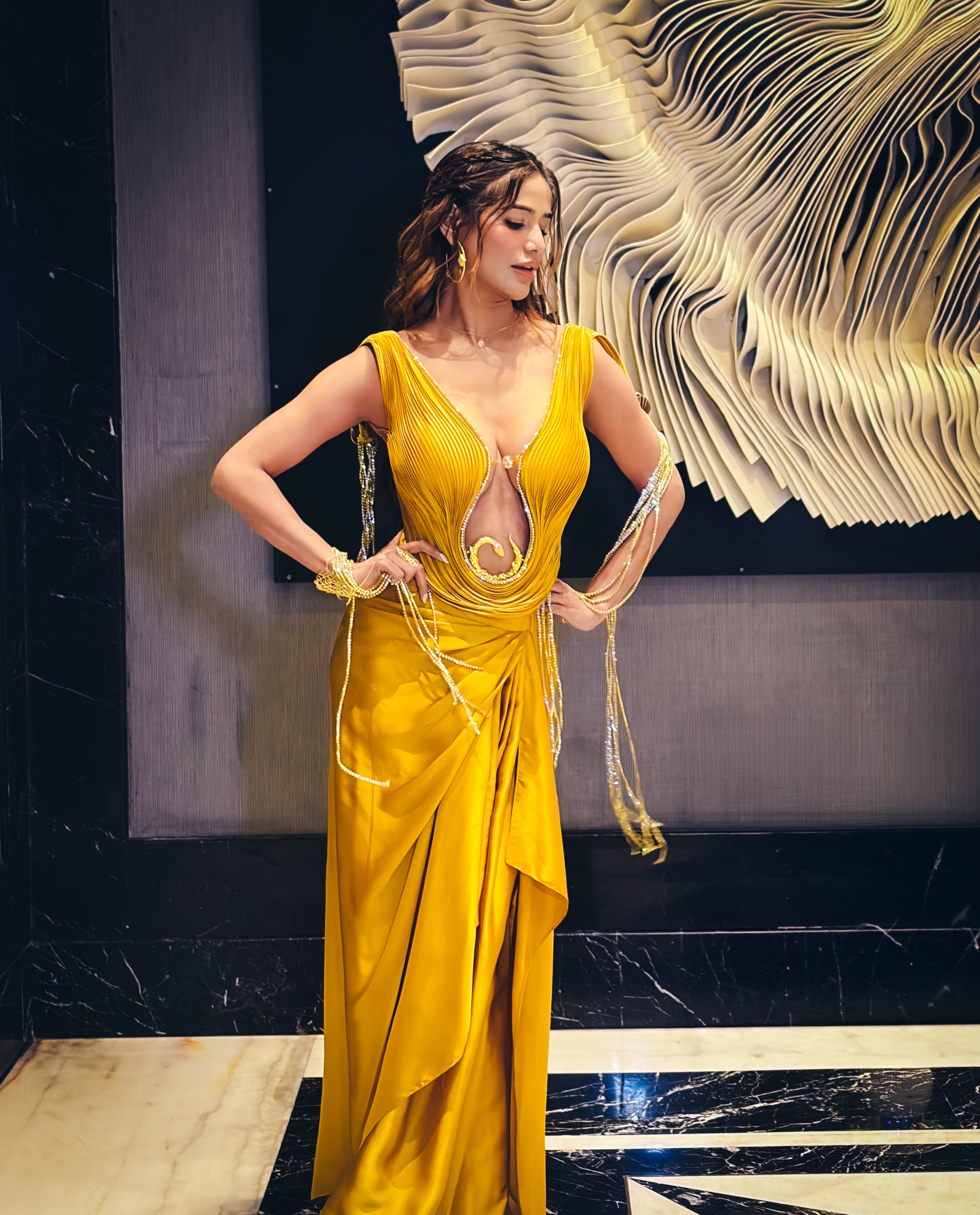 Poonam Pandey adds a contemporary edge to the ensemble with a daring neckline and intricate metallic accents.