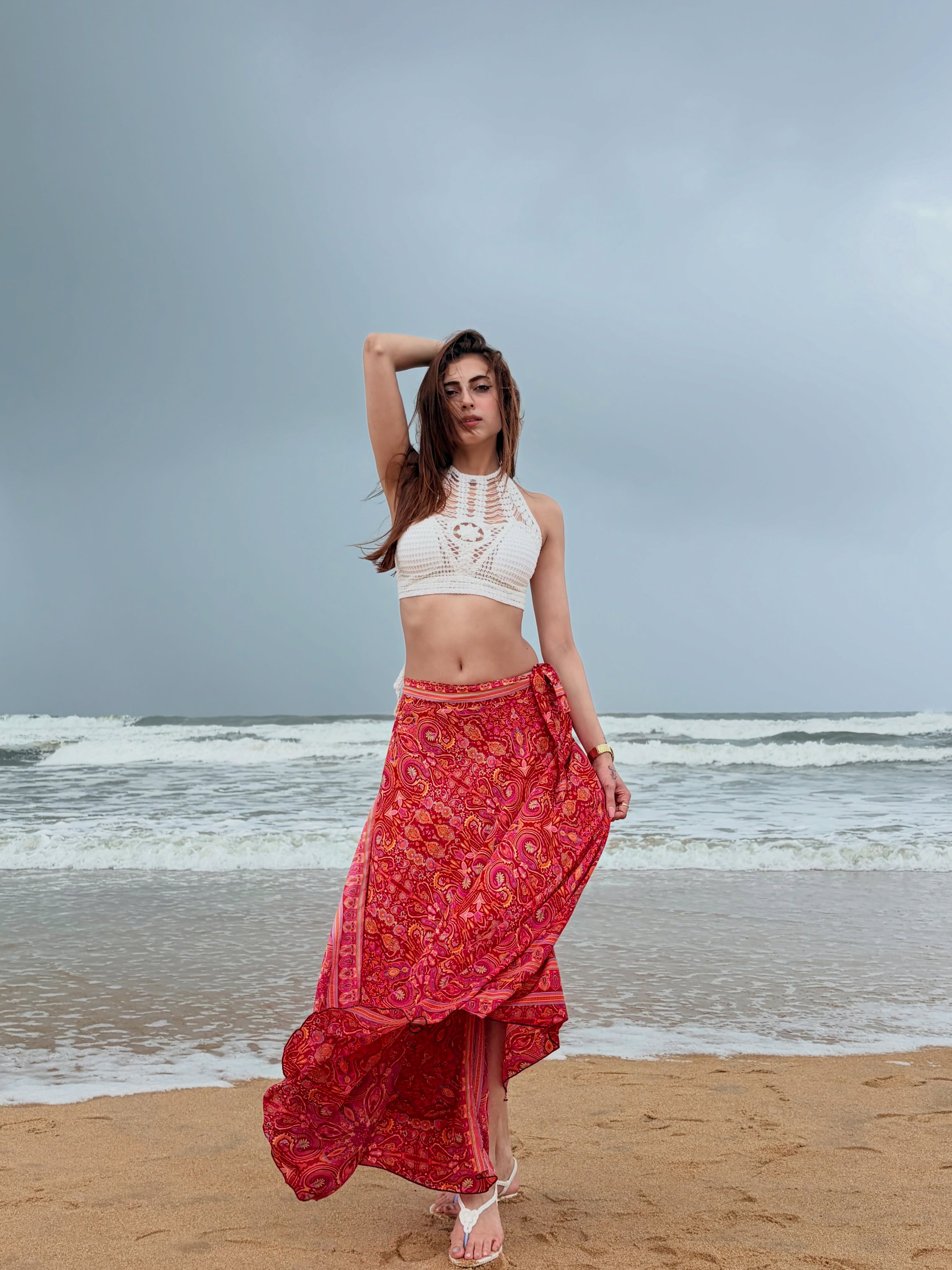 Farrhana Bhatt captivates in a white crochet halter top that brings a carefree yet stylish vibe to her beach look.