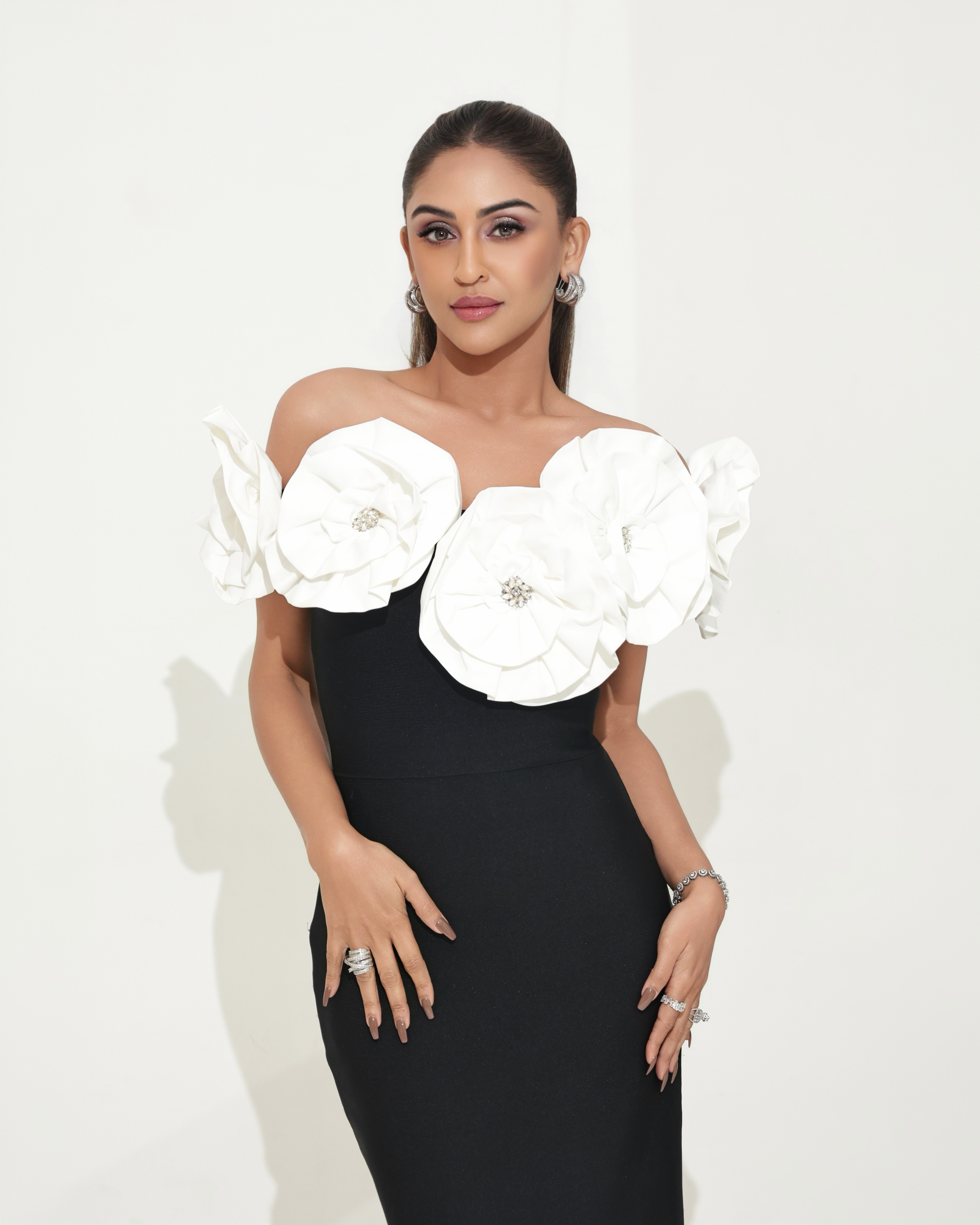 Krystle D'Souza turns heads in a sleek black gown elevated by oversized white floral appliqu&eacute;s, creating a bold yet elegant fashion statement.