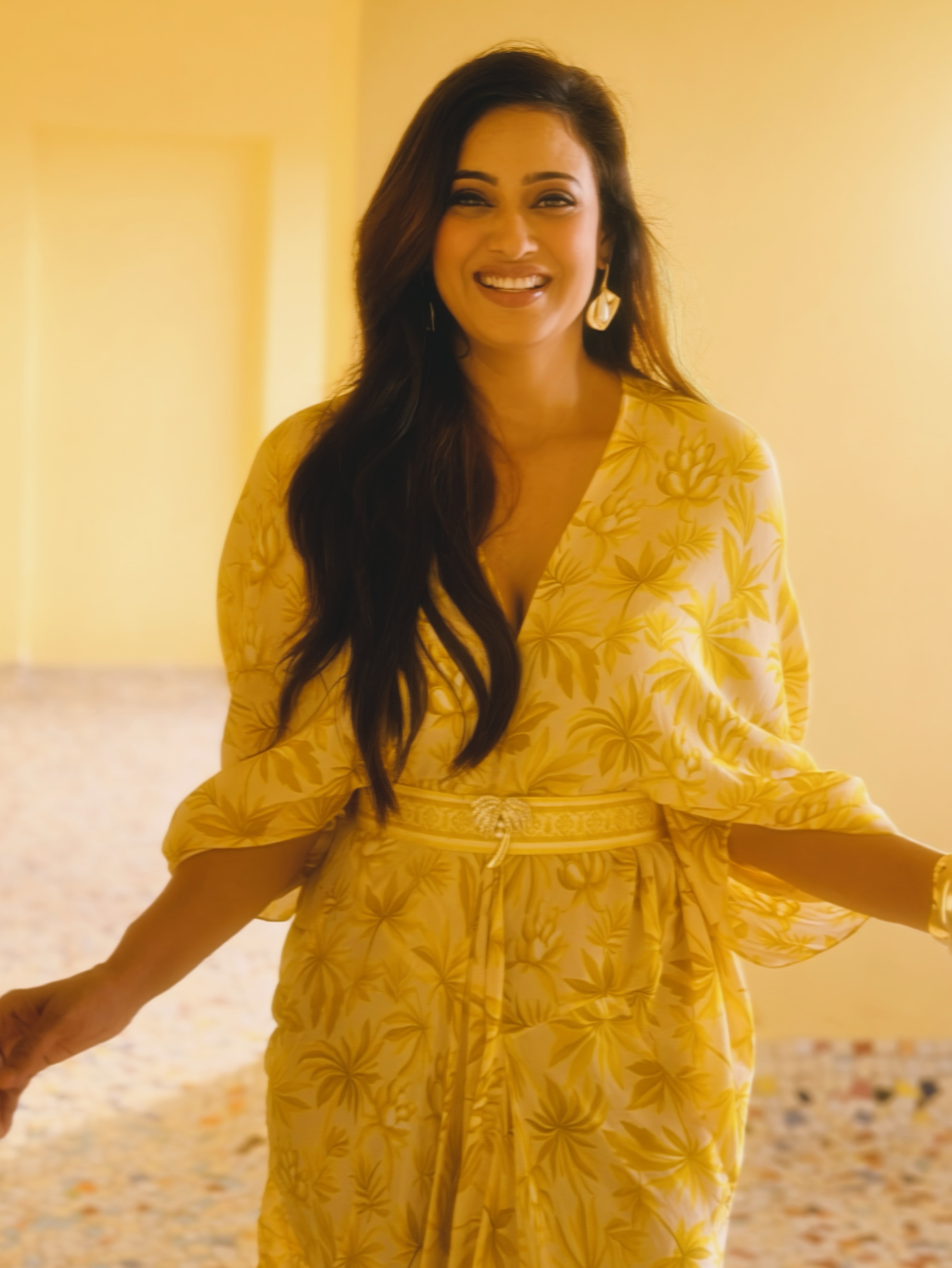 Shweta Tiwari stuns in a flowy yellow outfit adorned with delicate floral prints. The relaxed silhouette lends a graceful and refreshing appeal to her look.