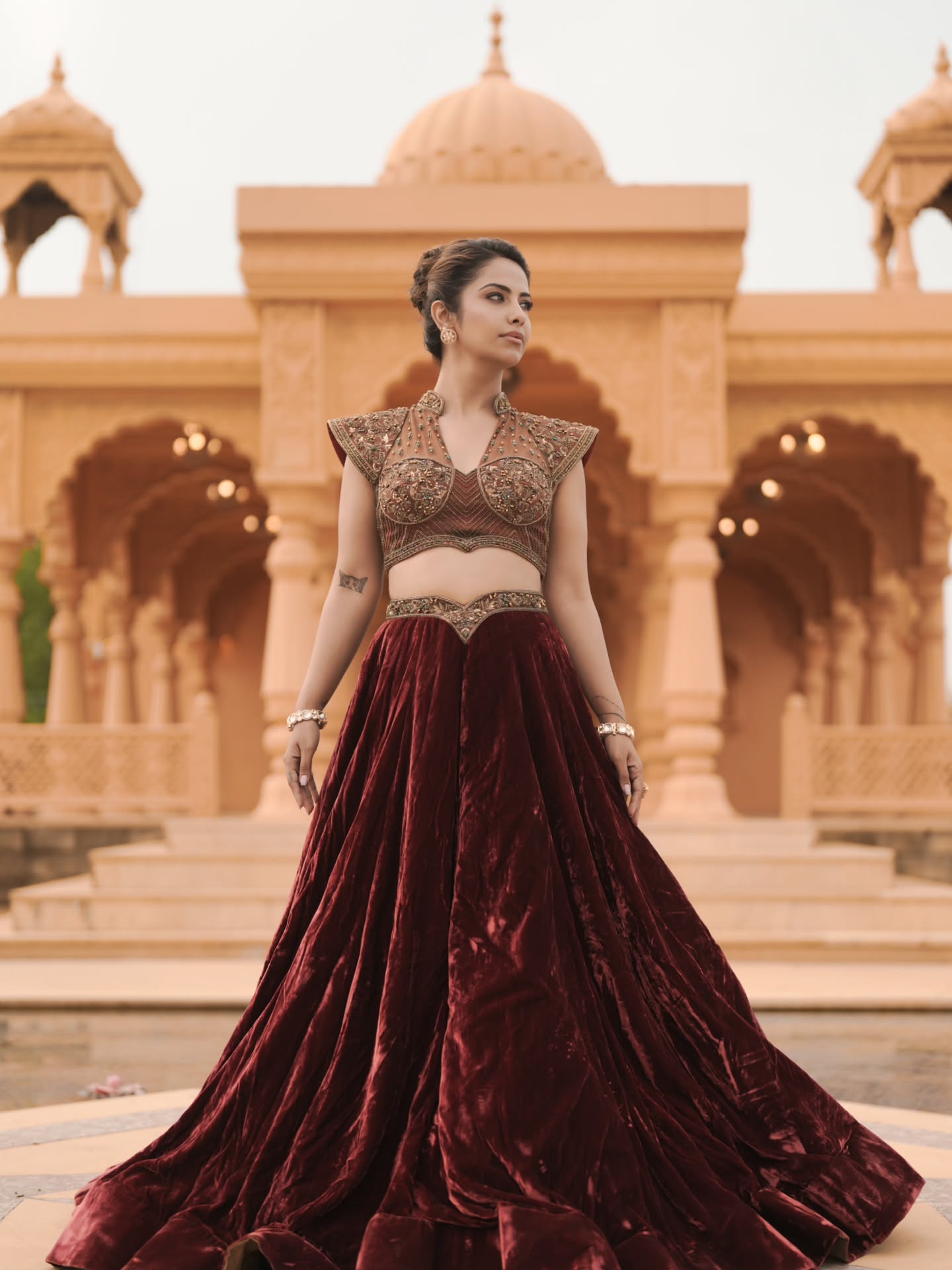 Avika Gor commands attention in a deep wine-hued velvet lehenga that flows gracefully, creating a dramatic silhouette with every step.