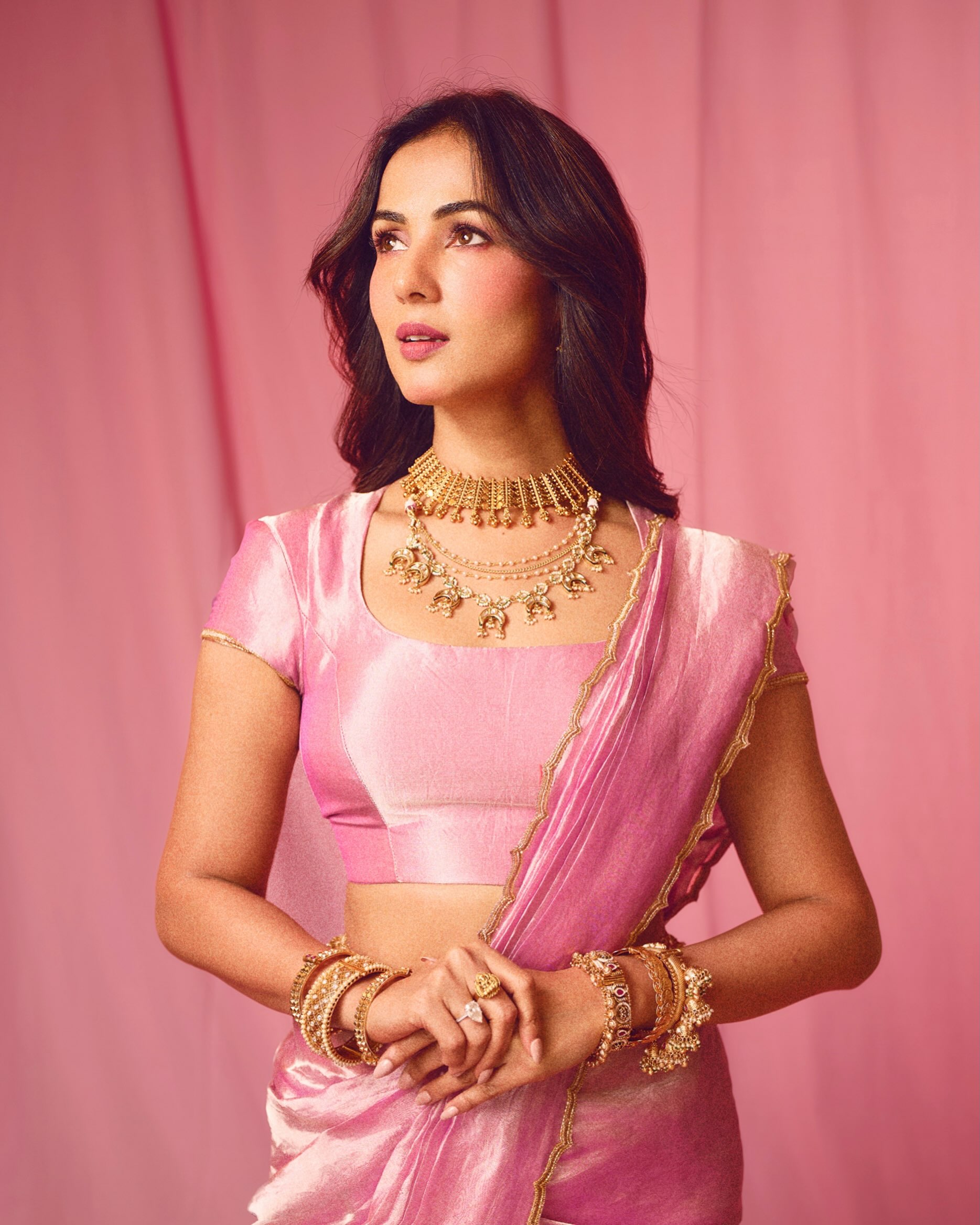 Sonal S Chauhan completes the look with softly defined eyes, rosy blush, glossy lips, and loose waves that beautifully complement the feminine aesthetic.