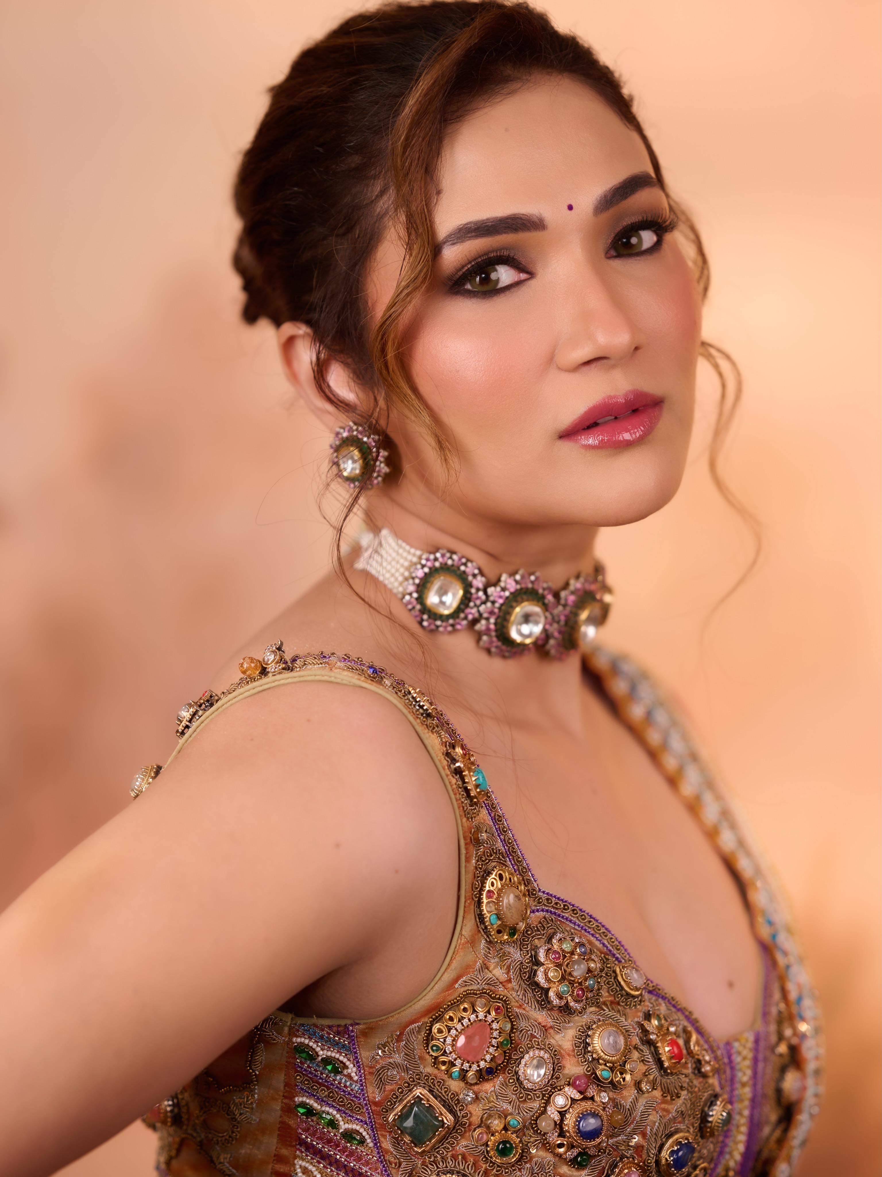 Ridhima Pandit completes the look with defined eyes, a soft pink lip, and hair swept into an elegant updo with loose face-framing strands.