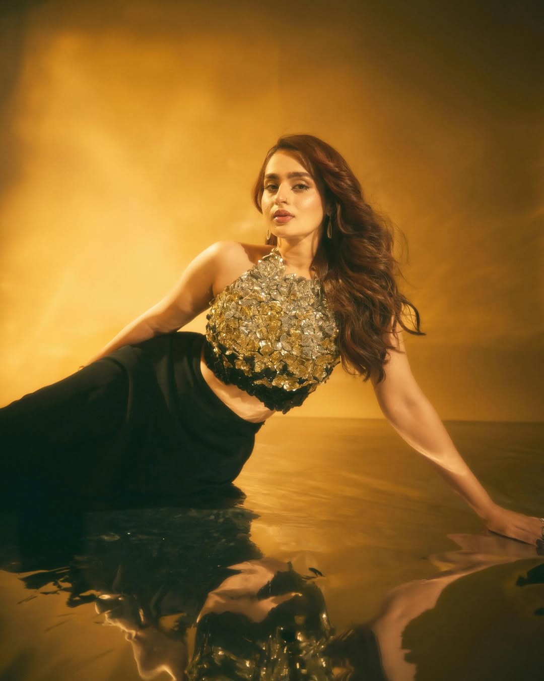 Ayesha Khan owns the look in a gold‑embellished cropped top packed with textured shine.