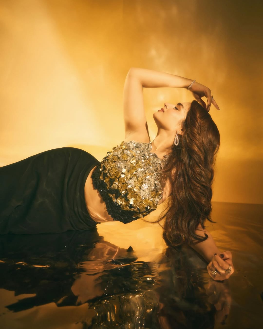 Ayesha Khan pairs it with a smooth, floor‑length black skirt that brings clean, sculpted drama.