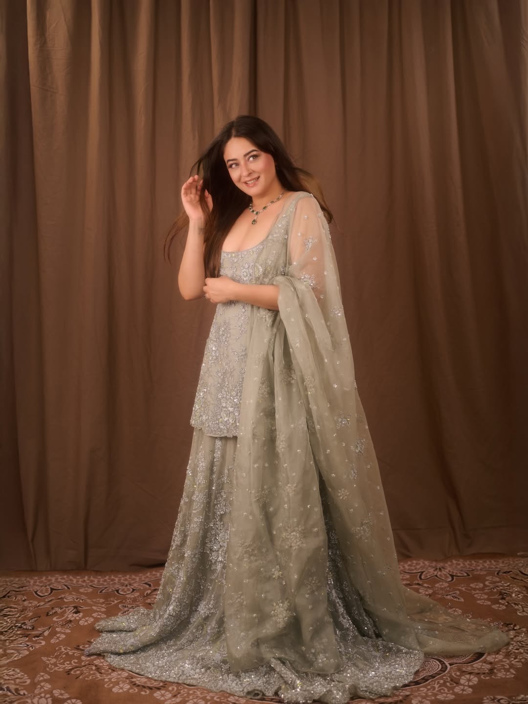 Mahhi Vij elevates the look with a lightweight dupatta featuring scattered shimmer and subtle texture that adds graceful movement.