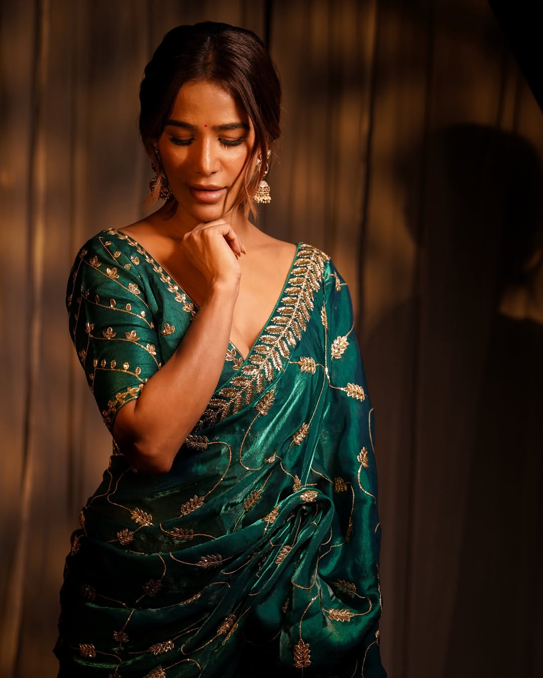 Poonam Pandey stands out in a deep green saree adorned with delicate gold embroidery, creating a rich and graceful visual appeal.