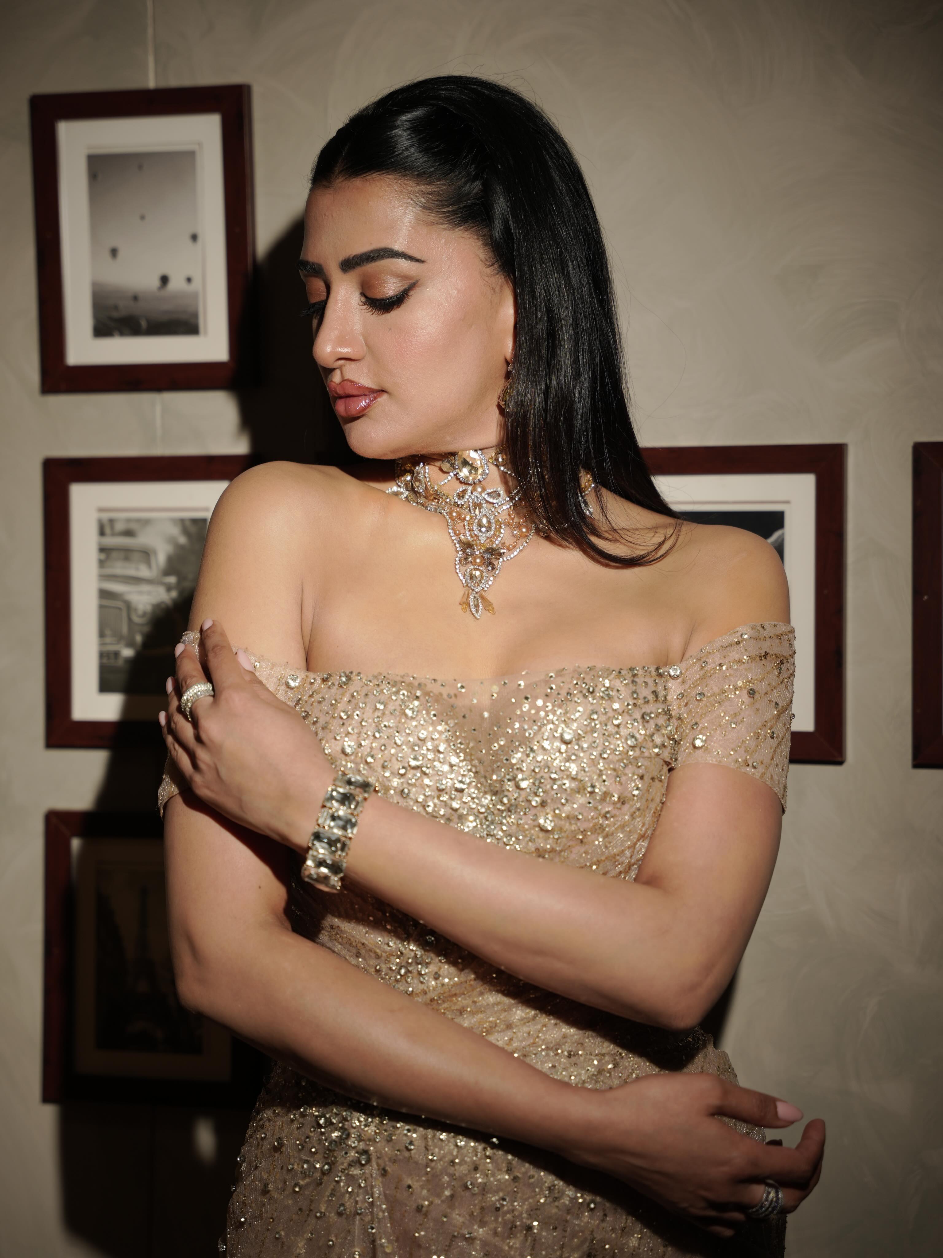 Pamala Serena elevates the look with a graceful neckline that adds a touch of classic glamour.