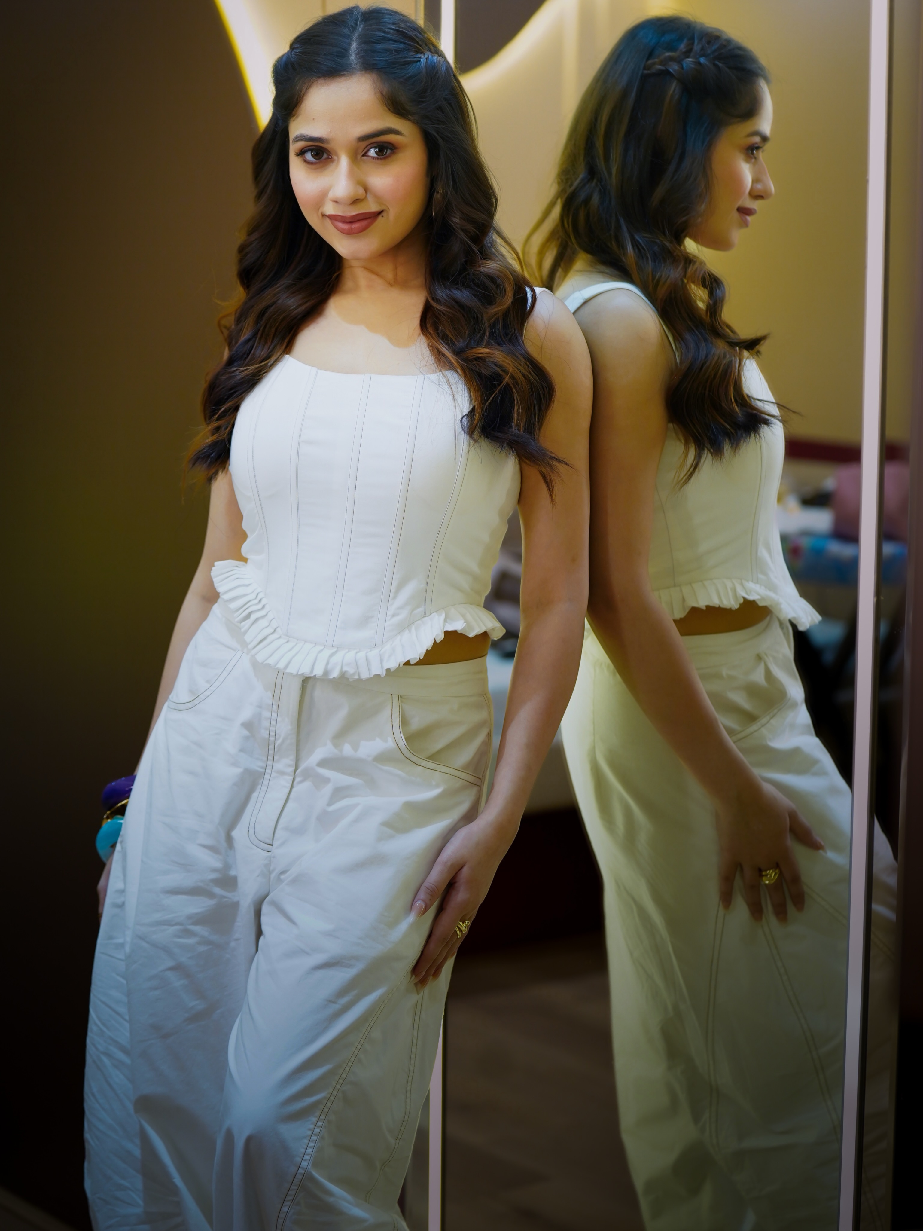 Jannat Zubair pairs the fitted top with wide-leg white trousers, creating a sleek monochrome ensemble that's equal parts stylish and sophisticated.
