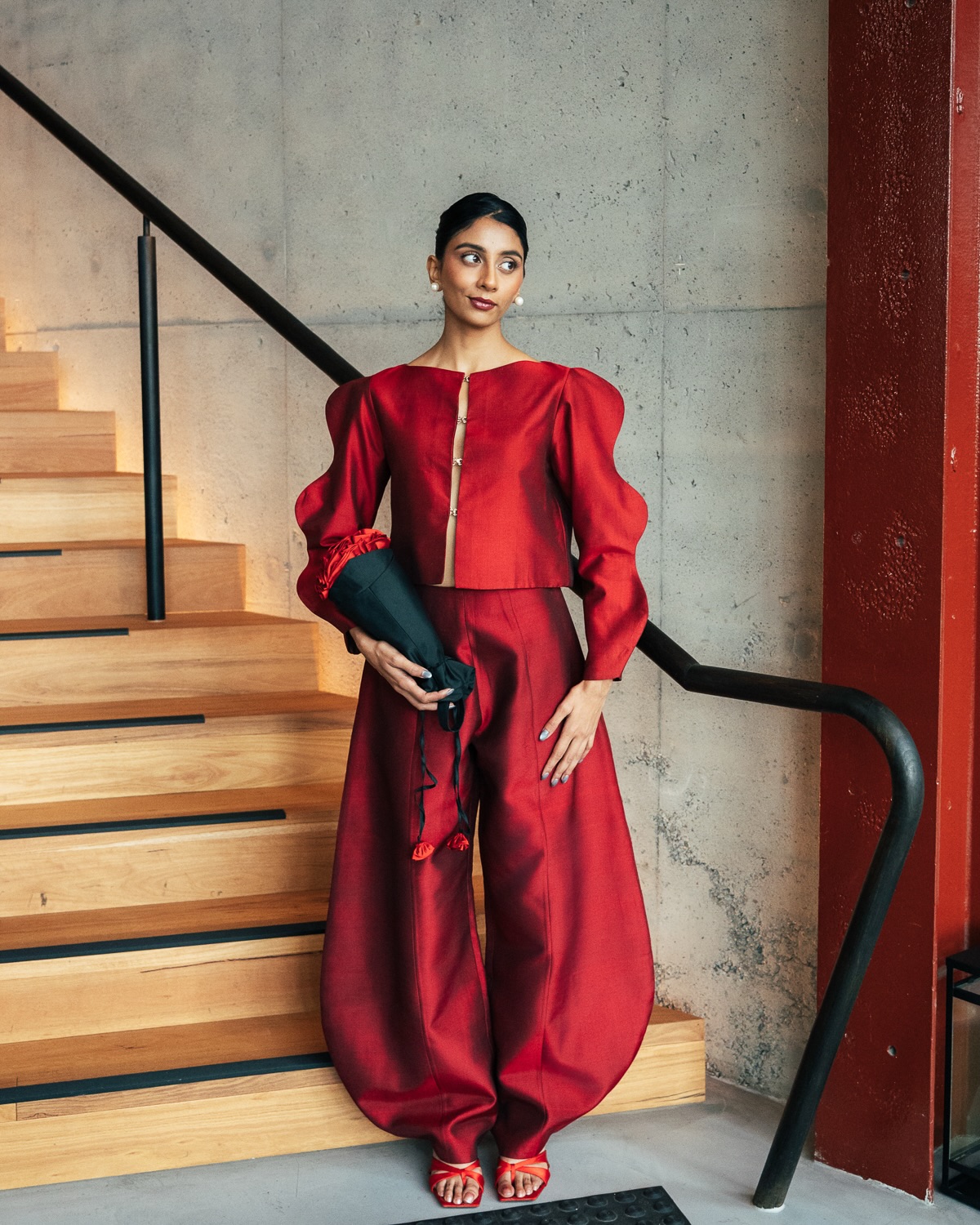 Dolly Singh commands attention in a vibrant crimson ensemble featuring a structured top and voluminous trousers that create an unforgettable fashion-forward look.