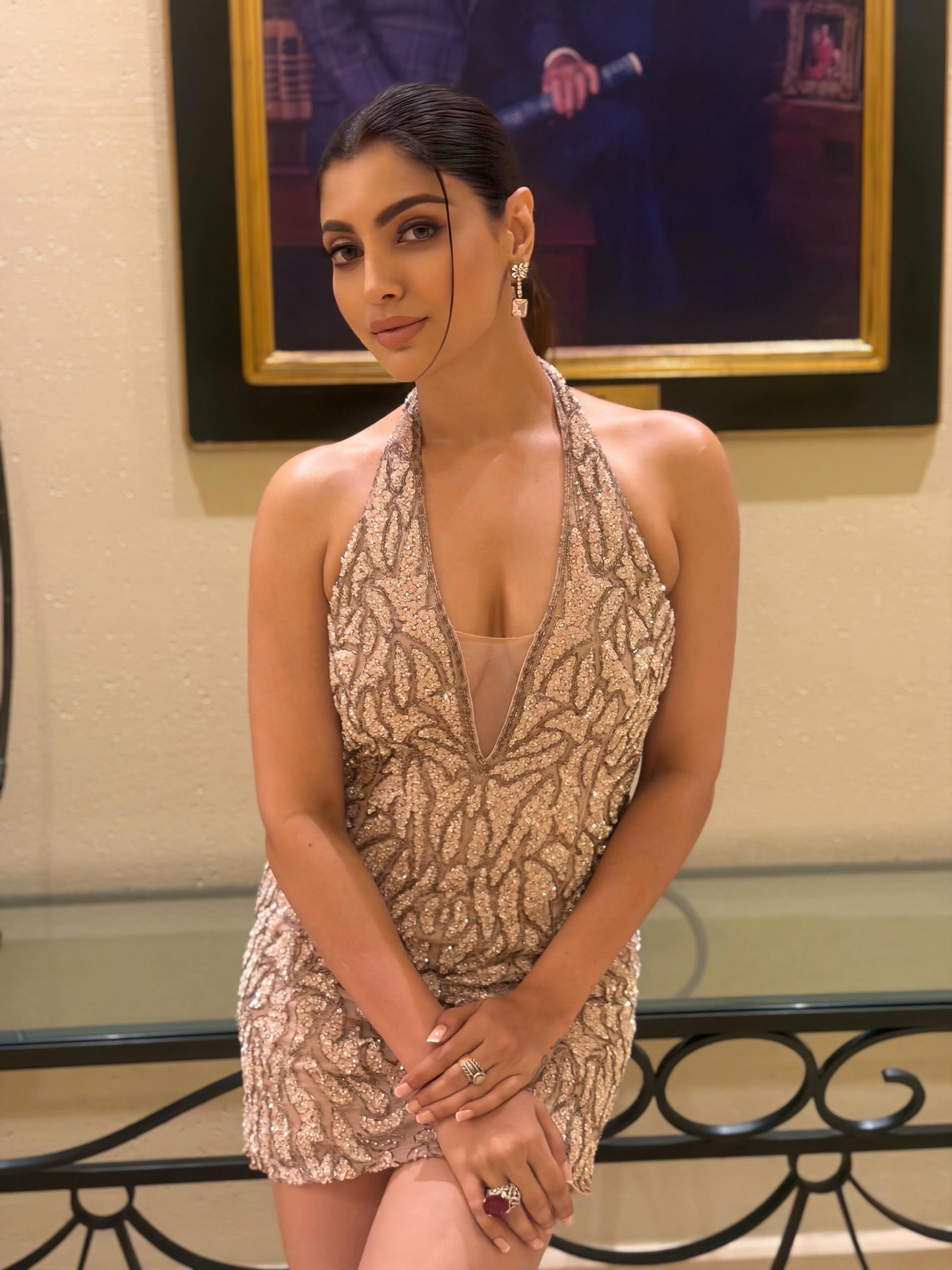 Akanksha Puri turns heads in a heavily embellished halter-neck mini dress adorned with intricate sequin detailing that catches the light from every angle.