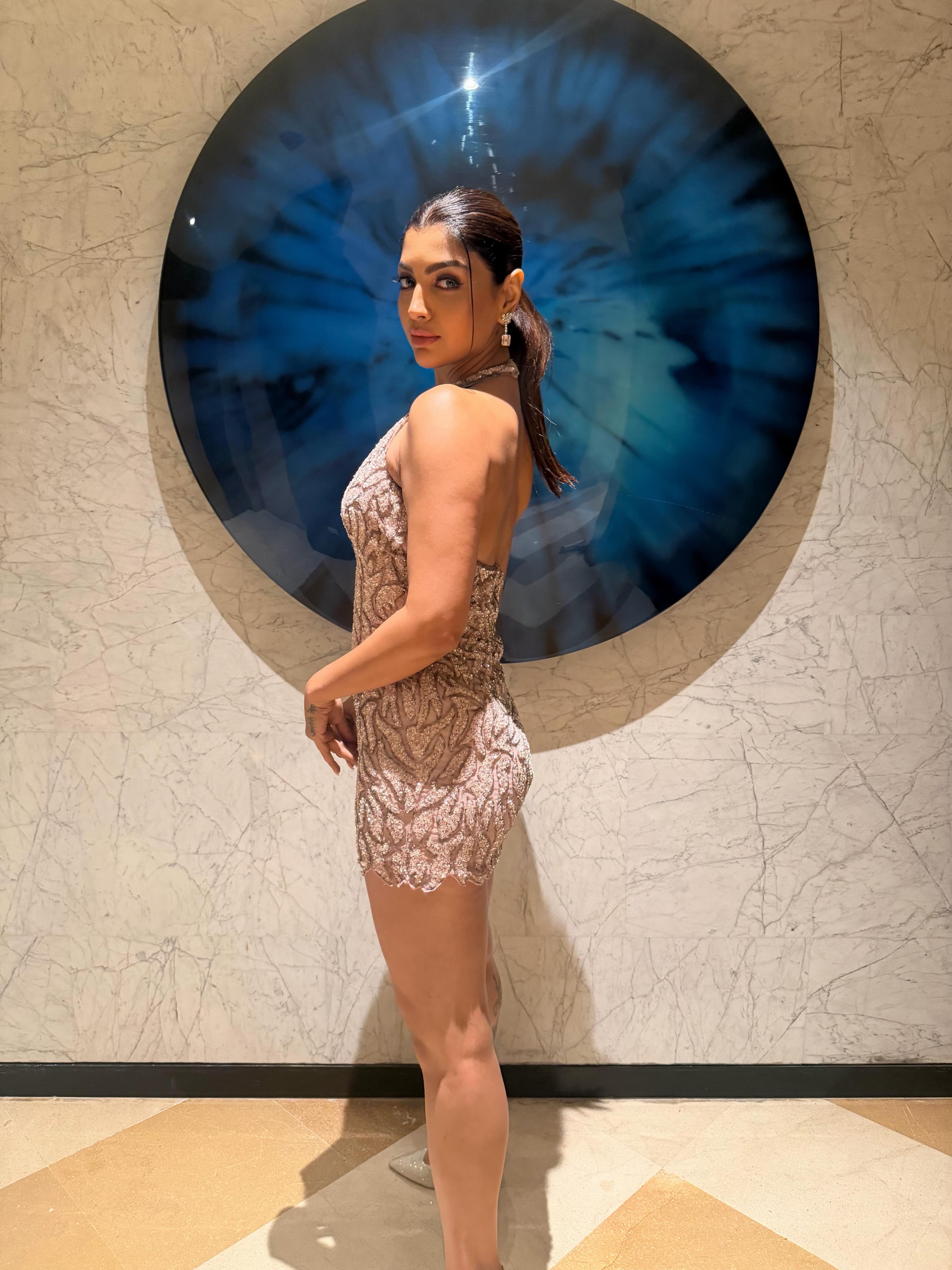 Akanksha Puri keeps the accessories understated with sparkling drop earrings and a delicate ring, letting the statement dress take centre stage.