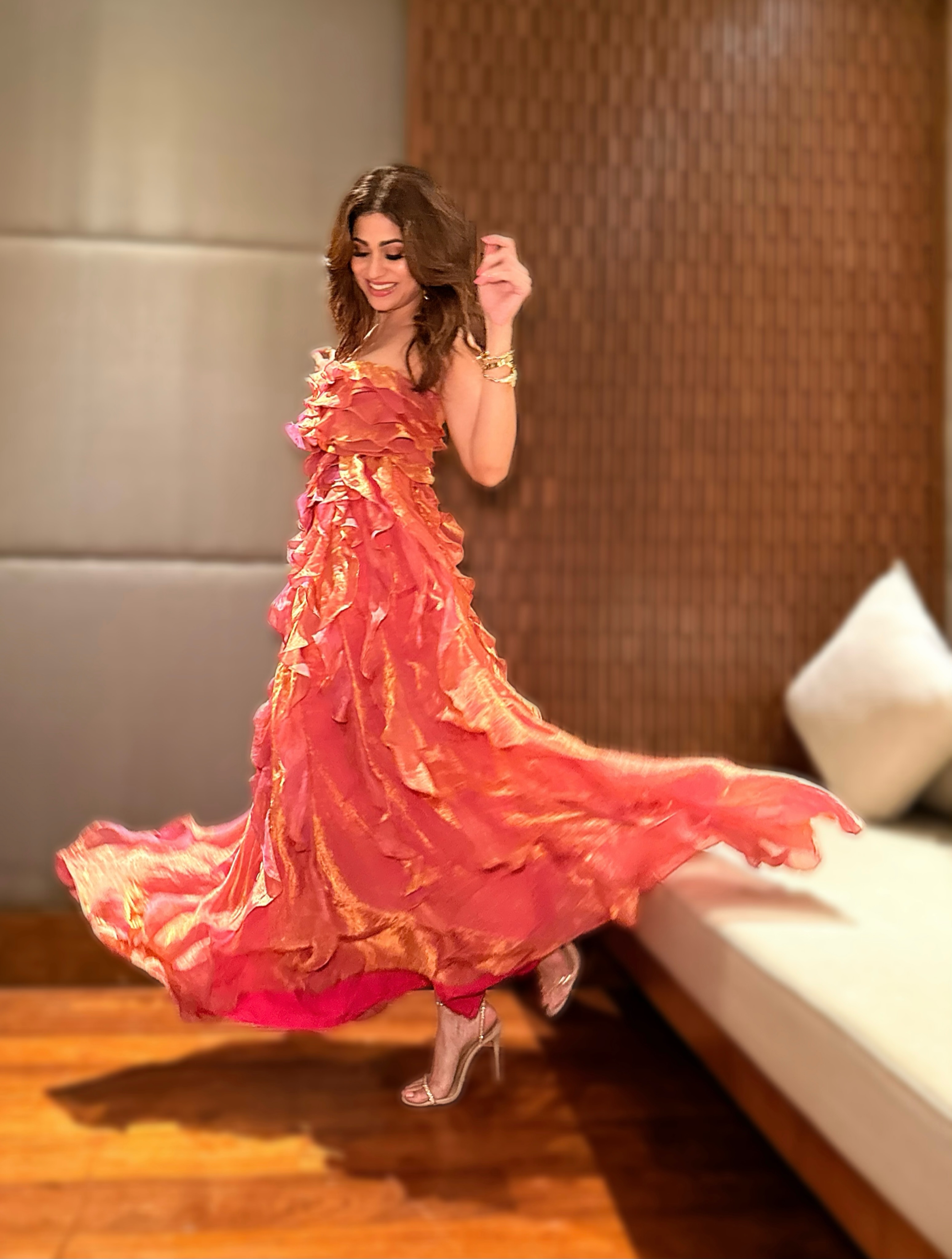 Shamita Shetty captivates in a coral-orange gown adorned with cascading ruffle details, creating a bold silhouette that's impossible to miss.