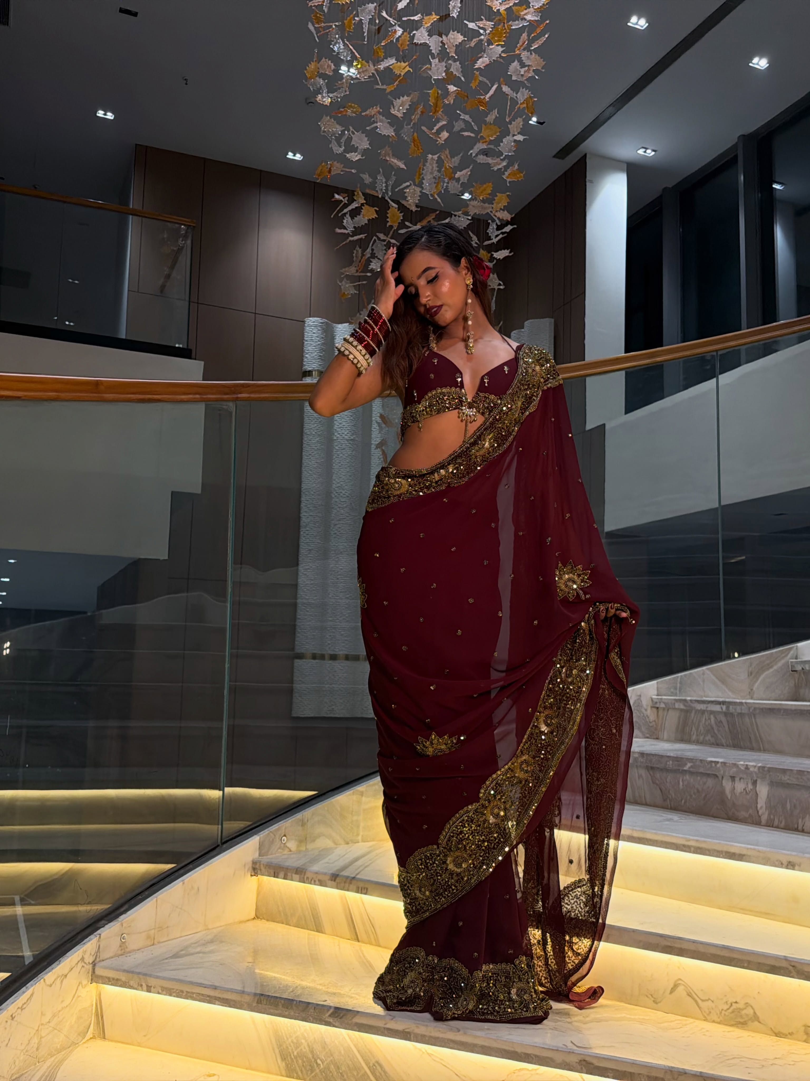 Nancy Tyagi pairs the saree with a heavily embellished blouse that perfectly complements the grandeur of the ensemble. The rich color palette enhances its festive appeal.